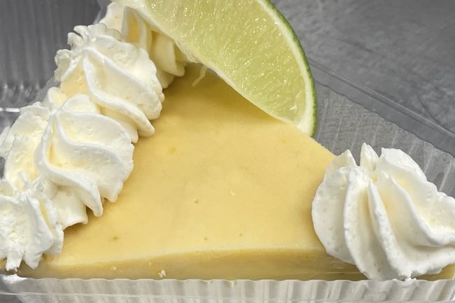 Keylime Pie Slice of lime pie topped with whipped cream and a lime wedge.